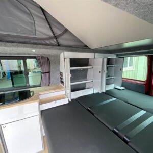 2020.07 VW T6 LWB Conversion Inside View of RIB Seat in Bed Position and Storage Cupboards Open